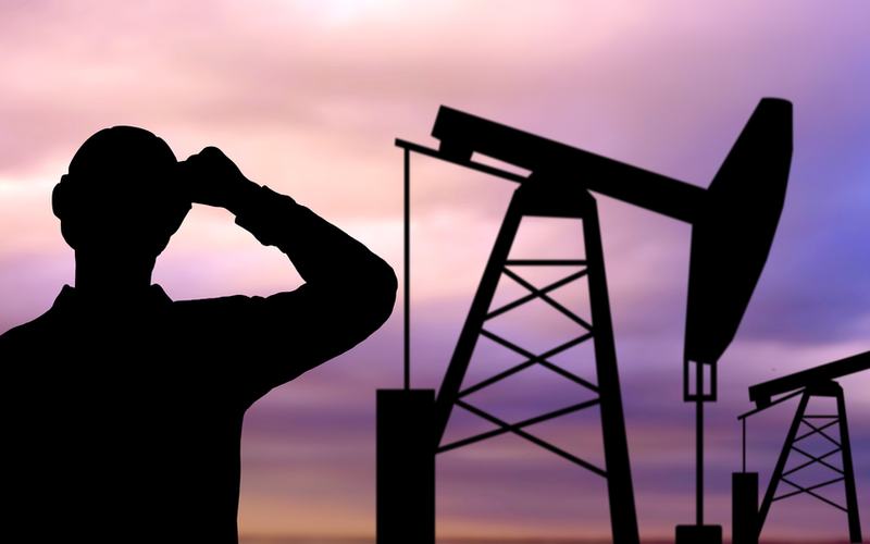 Oil Worker and Oil Rig - Shutterstock