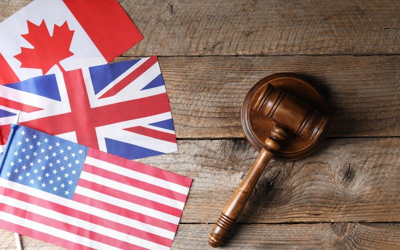 US, Canada, UK Flags and Gavel - Shutterstock